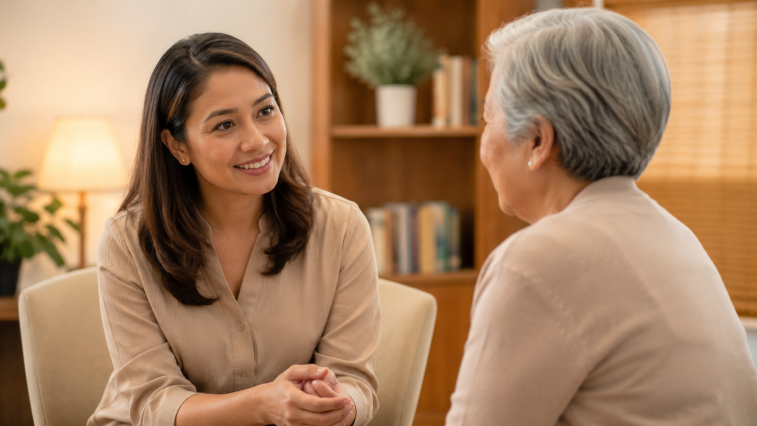 Filipina hearing care professional speaking with an older woman